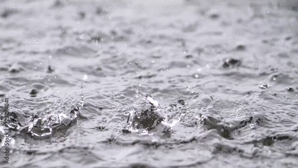 Rain water drops falling into lake in summer, slow motion in 180 fps, heavy rain close up view. Rain water drops falling into lake in summer, slow motion in 180 fps, heavy rain close up view.