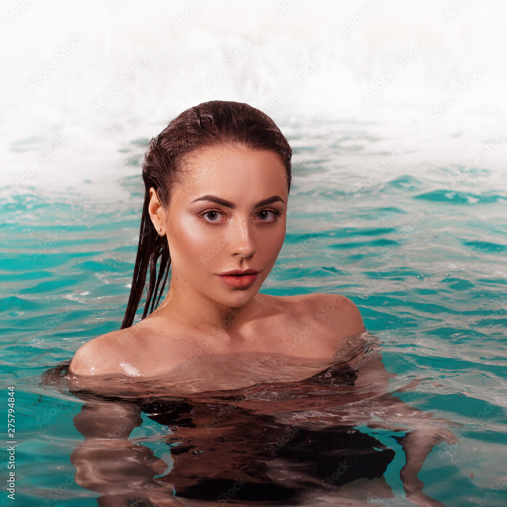 Beautiful young woman swimming in the pool, portrait.