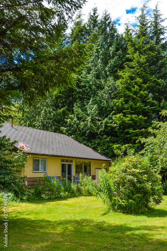 Frontage of a nice house among trees. Front side of a house on country side in British Columbia, Canada © Imagenet