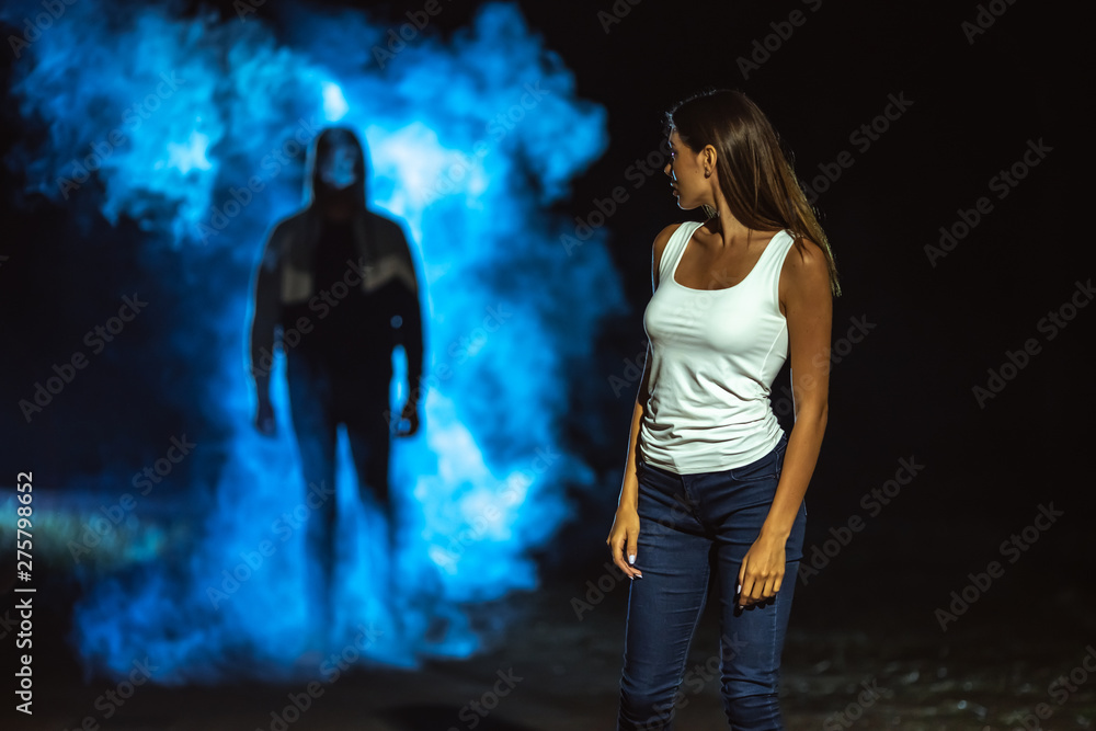 The man in the dark street following the woman