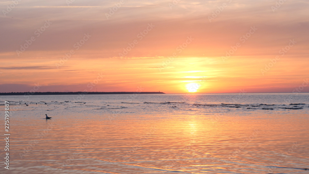 Beautiful fiery sunset sky on the beach. Composition of nature, Waves of the sea on a sandy beach.