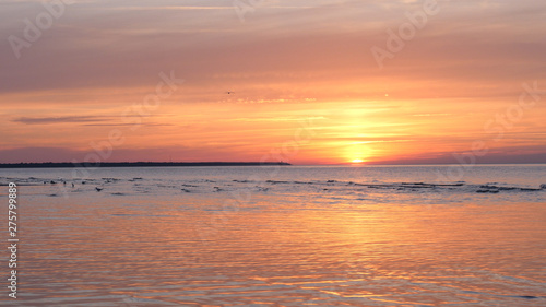 Beautiful fiery sunset sky on the beach. Composition of nature, Waves of the sea on a sandy beach.