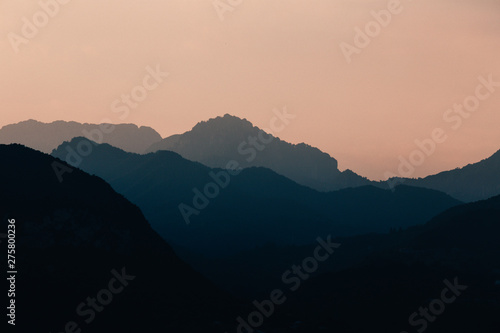 Natural patterns: layers of mountains in a foggy soft light at sunset. Garda Lake, Italy. Artistic, almost abstract