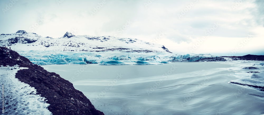 Huge majestic glacier's icy surface by snowy mountain in Iceland - obrazy, fototapety, plakaty 