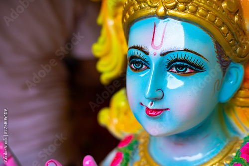 Fototapeta Naklejka Na Ścianę i Meble -  Closeup Portrait of  Hindu God Krishna in colorful high glossy statue.