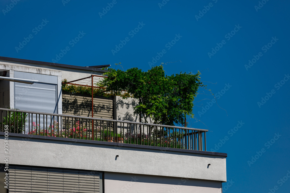 A balcony of a penthouse flat against a clear blue sky.