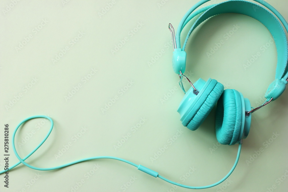 Headphones turquoise on a light green background. Copy Space. Headphones turquoise on a light green background. Copy Space.