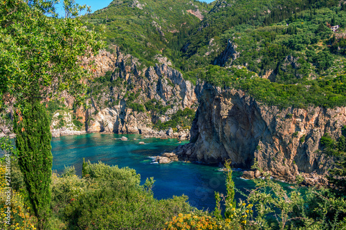 Beautiful landscape with sea     lagoon with turquoise water  mountains and cliffs  green trees and bushes  rocks in a blue water. Corfu Island  Greece. 