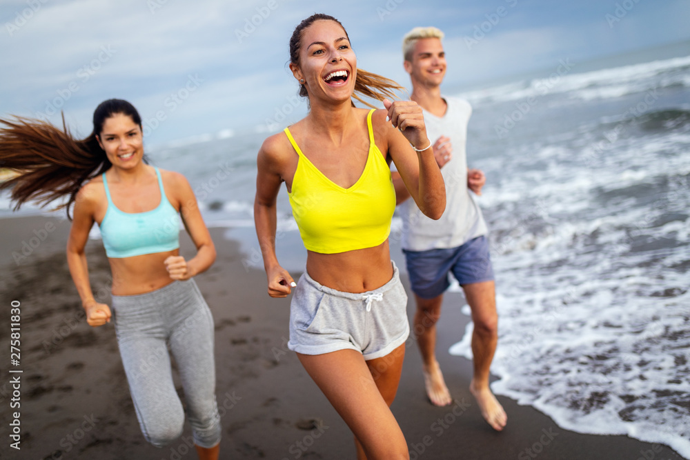 Group of young friends running and exercising on the beach Group of young friends running and exercising on the beach