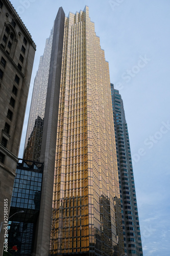 Reflection in bronzed mirrored building windows with blue sky and other buildings in downtown Toronto