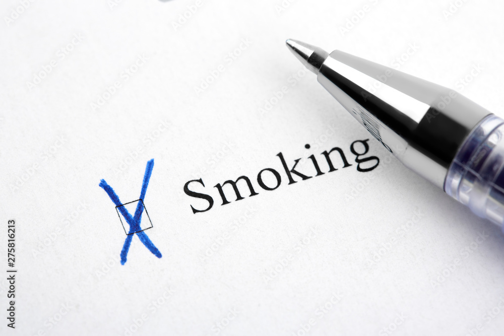 Fototapeta premium Smoking. Filling in the questionnaire, documents. The checkboxes are filled with a black pen on a white background. Questionnaire, survey.