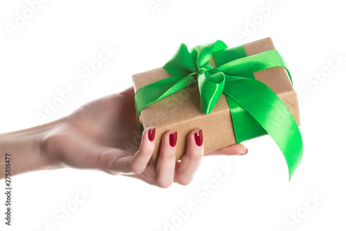 Fototapeta Naklejka Na Ścianę i Meble -  Hand woman holding gift box on isolated on white background. Gift wrap craft paper and green ribbon.