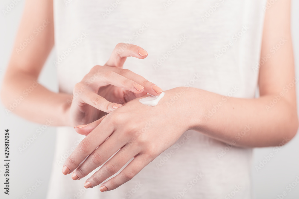 Spa treatment. Close Up of female hands applying hand cream. Woman holding cream tube and applying moisturizer cream on her beautiful hands for clean and soft skin. Spa treatment. Close Up of female hands applying hand cream. Woman holding cream tube and applying moisturizer cream on her beautiful hands for clean and soft skin.