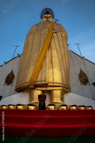 A golden tall Buddha standing at wat Intharawihan.This 32 metre high and 10 feet wide Buddha is the biggest of its kind in the world. Wat Intharawihan is on wisut Kasat road Bangkok Thailand. photo