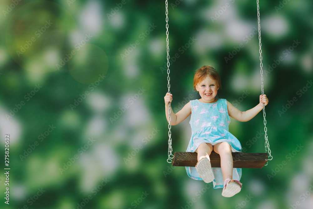 a girl riding on a swing outdoors