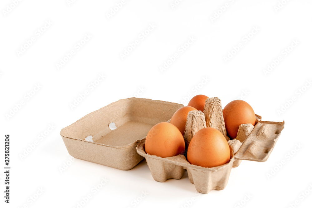 ฺBrown chicken eggs in an open egg carton or raw chicken eggs in egg box isolated on white background. full depth of field. With copy area