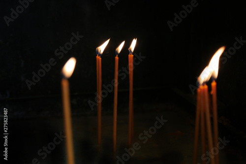 Candle flames on a black background. Burning prayer candles in the church.