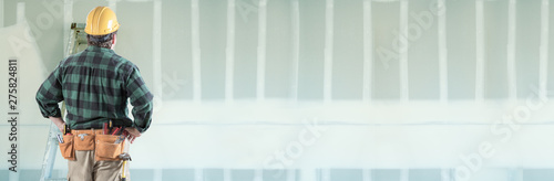 Konstfotografi Male Contractor Wearing Hard Hat Facing Drywall Banner Background with Ladder