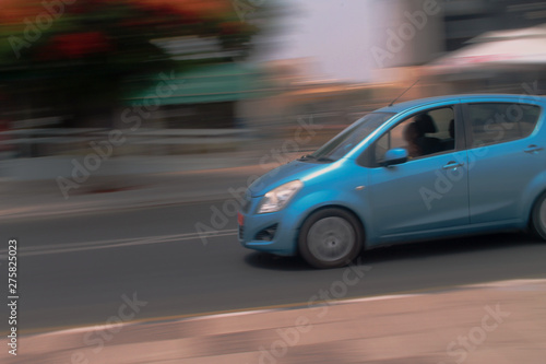 Blue car moving fast along the street © Olga