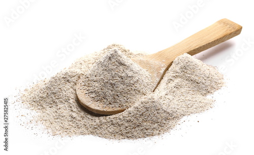 Integral rye flour pile in wooden spoon isolated on white background