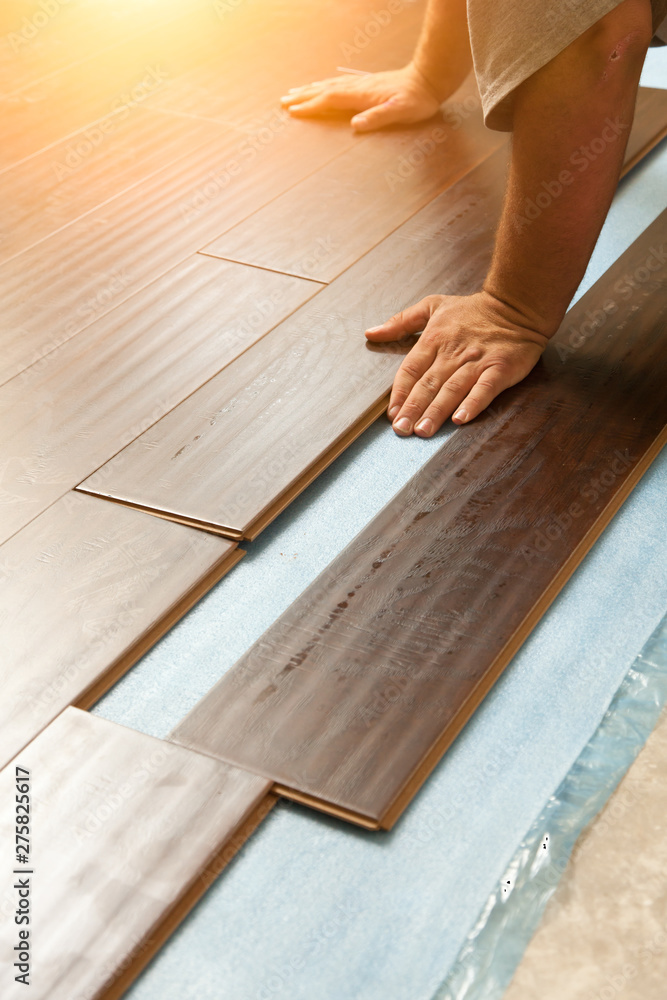 Man Installing New Laminate Wood Flooring Man Installing New Laminate Wood Flooring