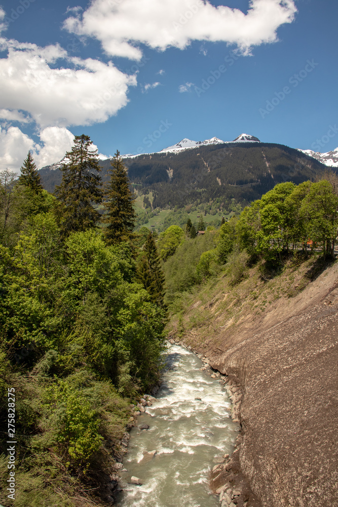 View of a river with high mountains in the background in the Swiss Alps in the Davos / Kloster area. View of a river with high mountains in the background in the Swiss Alps in the Davos / Kloster area.