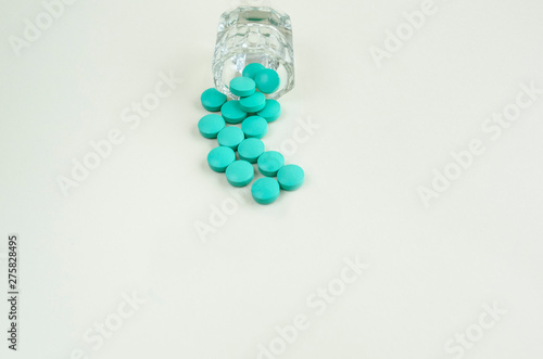 Pills spilling out of pill bottle on white background. copy space.