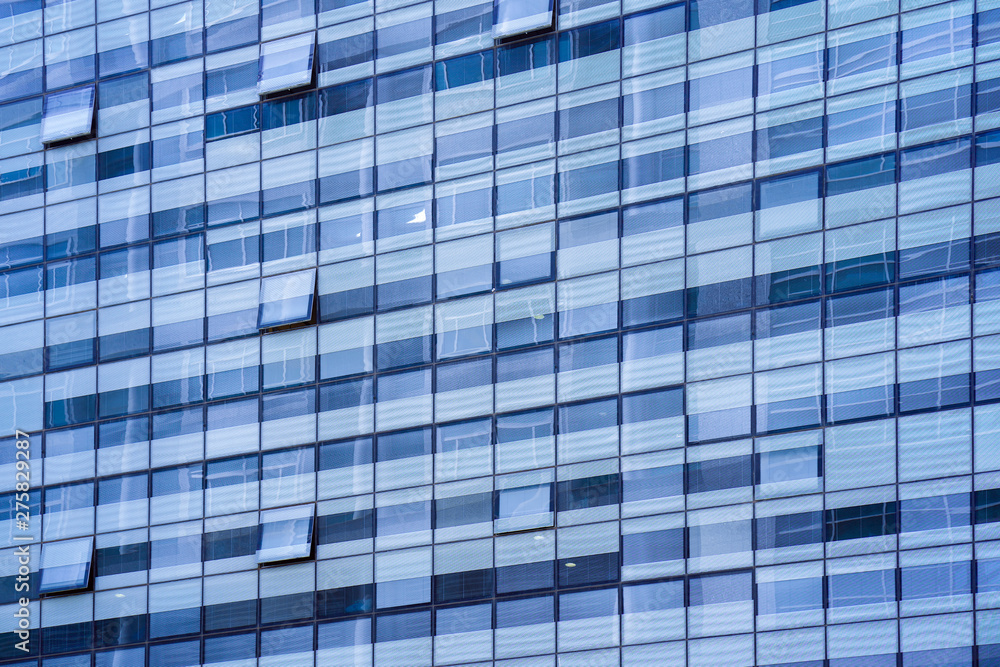 Glass blue square Windows of facade modern city business building skyscraper. Modern apartment buildings in new neighborhood. Windows of a building, texture. Glass blue square Windows of facade modern city business building skyscraper. Modern apartment buildings in new neighborhood. Windows of a building, texture.