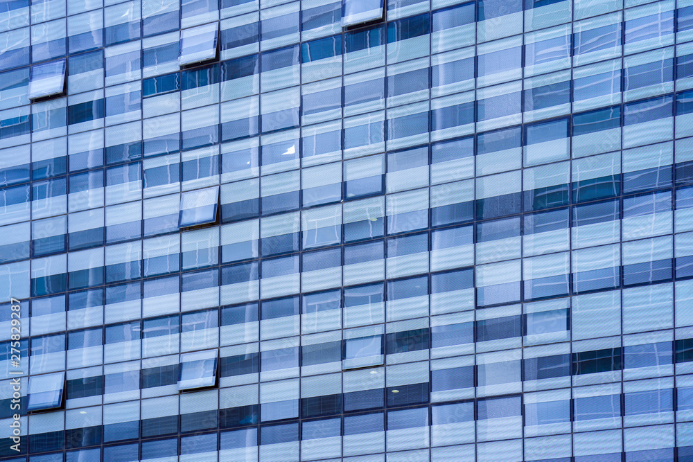 Glass blue square Windows of facade modern city business building skyscraper. Modern apartment buildings in new neighborhood. Windows of a building, texture.