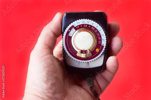 old vintage Soviet exposure meter with leather case on red background