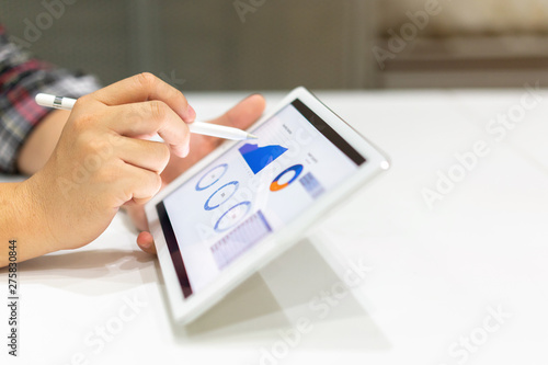 close up businessman hand using stylus pen on screen dashboard of graph and chart statistics data for analyzing about profit monthly , business and financial concept photo