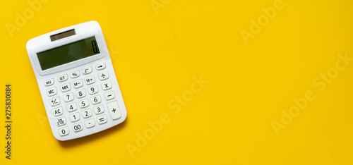 close up white calculator on yellow background for business financial concept photo