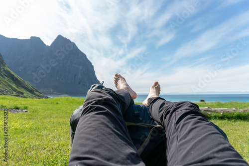 Resting with feet on backpack on kvalvika beach in lofoten