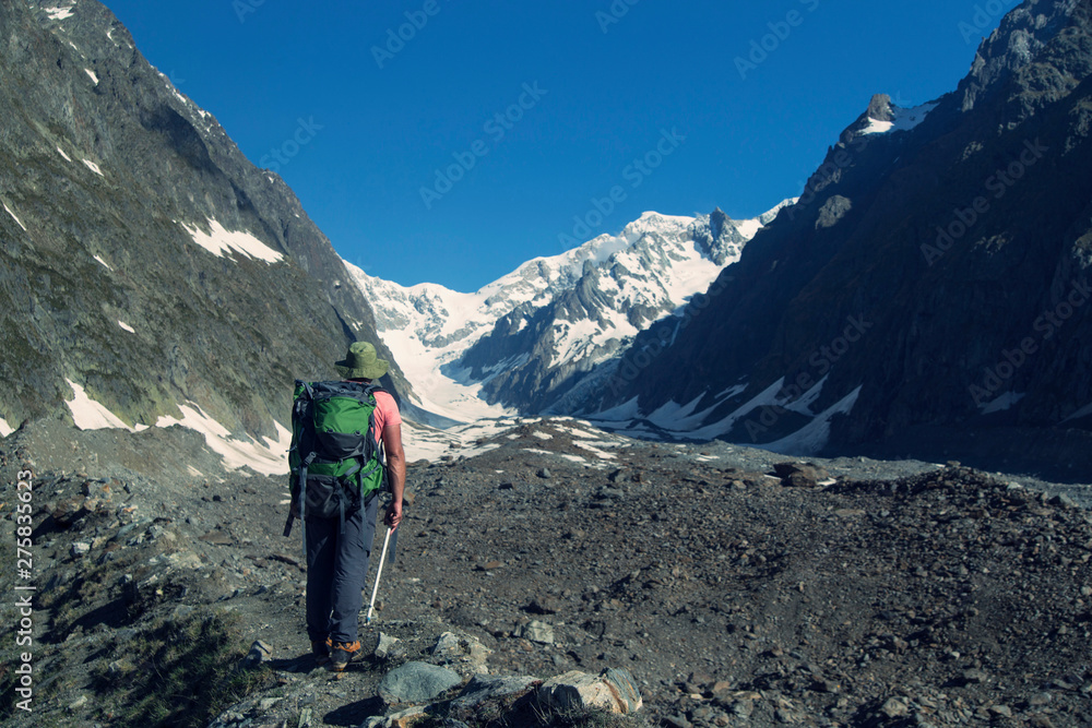 Hiker traveling in Alps. Alpine peaks landskape background. Jungfrau, Bernese highland. Sport, tourism and hiking concept.