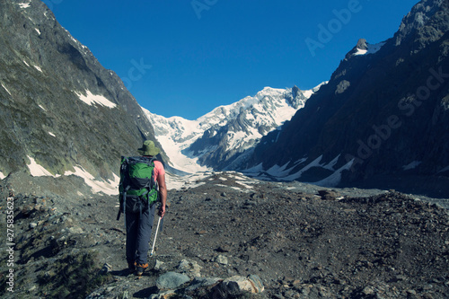Hiker traveling in Alps. Alpine peaks landskape background. Jungfrau, Bernese highland. Sport, tourism and hiking concept.
