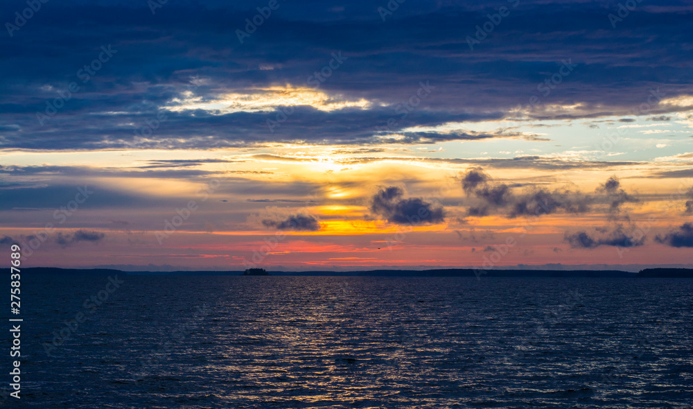 Obraz premium bright colorful sunset with yellow orange pink blue colors and clouds on the sky above big river Volga in Russia 