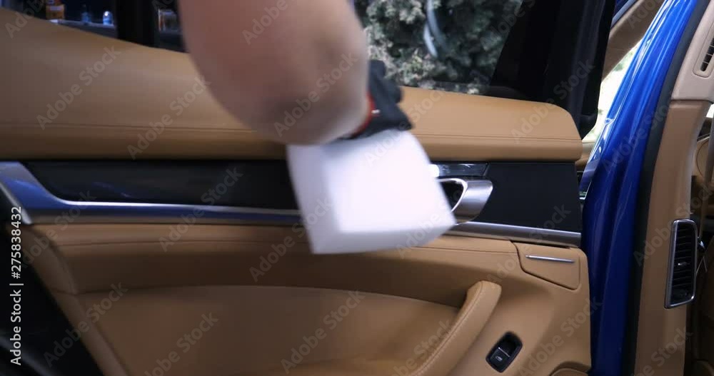 A woman at a car wash does a full dry-cleaning of all parts of a car using special chemistry, cloths, sponges and brushes. Concept of: Full car cleaning, Dry cleaning, Professional service. Car, Work. A woman at a car wash does a full dry-cleaning of all parts of a car using special chemistry, cloths, sponges and brushes. Concept of: Full car cleaning, Dry cleaning, Professional service. Car, Work.