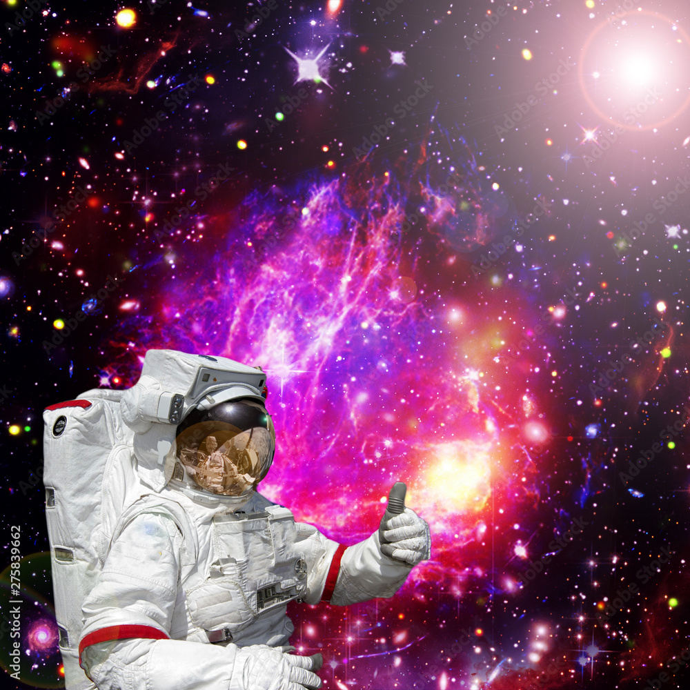 Astronaut gives thumbs-up against outer space, galaxies and stars. The elements of this image furnished by NASA. Astronaut gives thumbs-up against outer space, galaxies and stars. The elements of this image furnished by NASA.