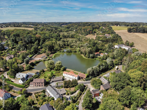 Aerial view of country side area in Walloon Brabant, Belgium. Luxury villas with garden surrounded by forest and small lake during autumn season