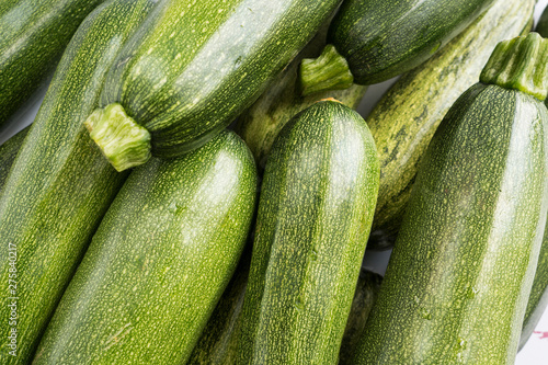 Green fresh zucchini stacked in a heap shot from above. Background of fresh zucchini. Top view. photo