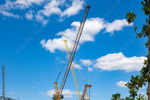 Two construction cranes with crossed arrows