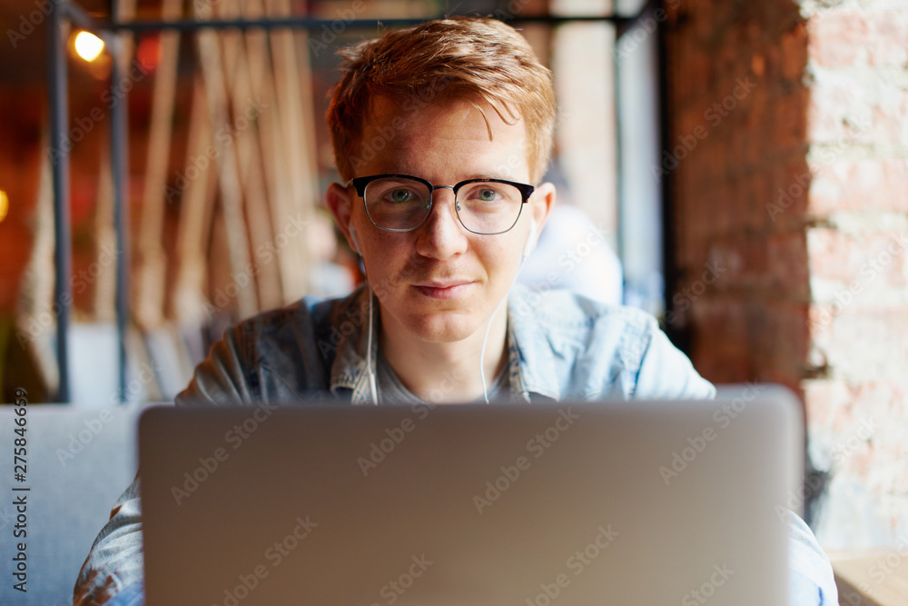 Young man works on the laptop in the cafe. Young man works on the laptop in the cafe.