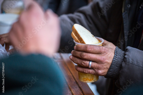 Charity. The fight against poverty. Volunteers handed out hot meals to people in need. Cold winter day in the big city.