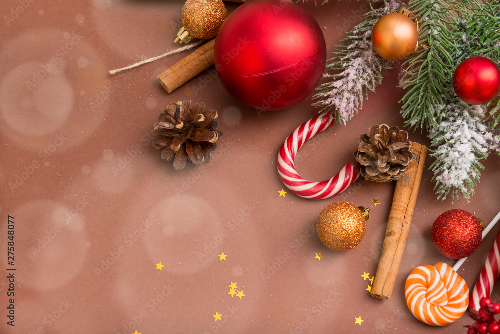 fir branch, fir cones, gold and red Christmas balls, Lollipop on a brown background, cinnamon sticks, stars