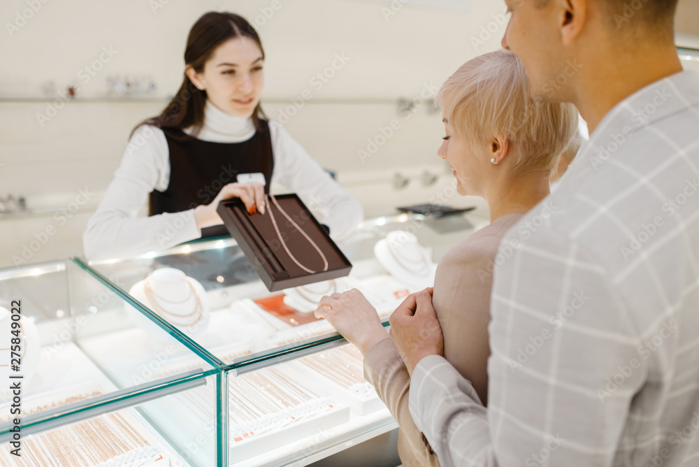 Love couple buying gold necklace in jewelry store Love couple buying gold necklace in jewelry store