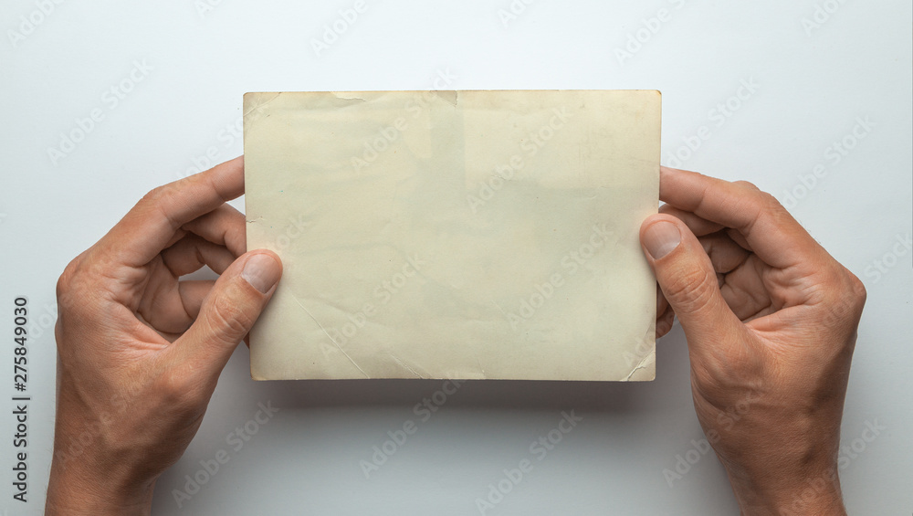 Old photo in the hands of man. Empty template for picture, mock-up. Gray background. Old photo in the hands of man. Empty template for picture, mock-up. Gray background.