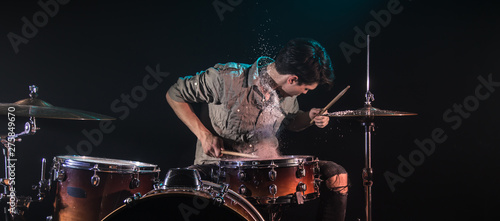Photography musician playing drums with splashes, black background with beautiful soft light
