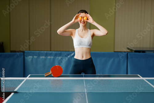 Young woman puts ping pong balls to her eyes