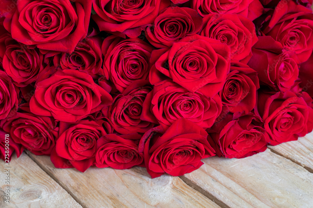 Bukiet czerwonych róż na drewnianym  stole - obrazy, fototapety, plakaty 