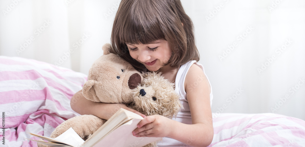 Cute little girl smiling while lying in a cozy white bed Cute little girl smiling while lying in a cozy white bed